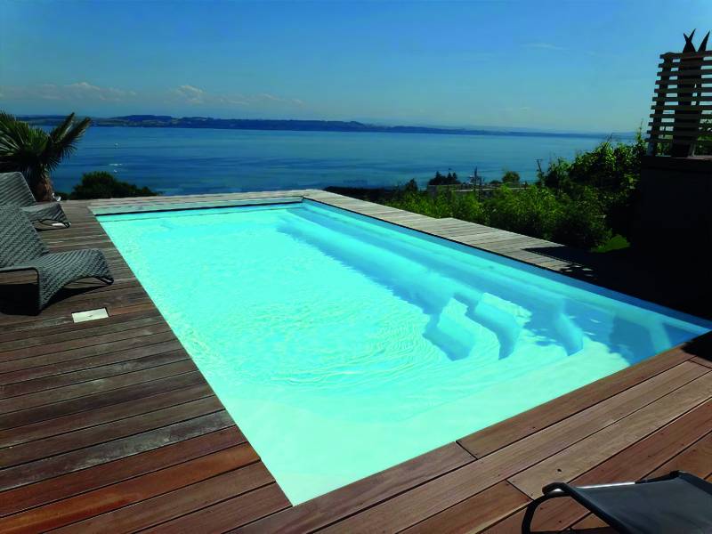 Magnifique réalisation de piscine enterrée moderne dans un jardin du Luberon. Pose de la coque polyester avec margelles claires par Generale Piscines à Gargas.